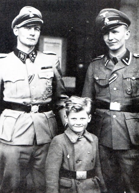Christian Frederik von Schalburg hilser på Søren Kam. I forgrunden ses Schalburgs søn i en mini-SS-uniform. 